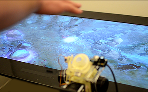 Free air sensations can be delivered to a user that map to a wide range of textures. Here a user can control a virtual character moving over textures such as water and grass. (Photo and caption credit Disney Research, see link above)