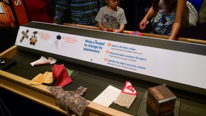 This was the low-tech version of mapping a surface onto a wireframe object. There was a very simple (frustratingly so, for adults) virtual interactive that allowed you to 'paint' a car hood with different projections, but I actually liked this better, for any number of reasons including the fact that different surfaces on the same shape create very different objects, and because it showed at least a little what kinds of deformations and folds you need to make in a surface texture when putting it on a 3D object.